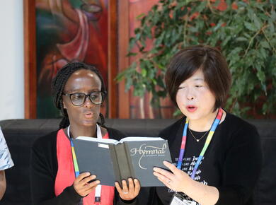 an african and a korean woman share a hymnal