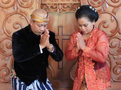 Reverend Budi Santoso with his wife in traditional costumes, beskap (for men) and kebaya (for women)